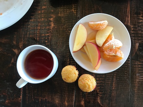 Breakfast with hot tea, cup cake and fruits