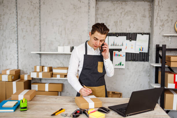 istock Small business owner talks with customers while packing products 1447698997