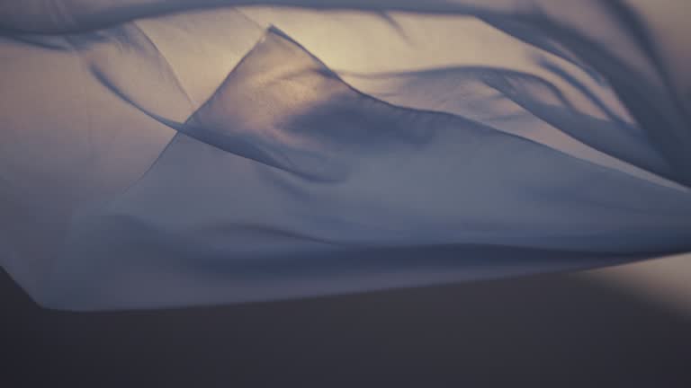 White transparent fabric waving on the wind at sunset