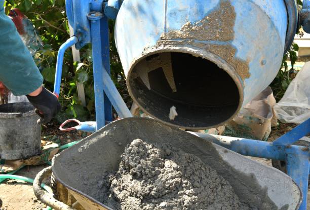 istock A bricklayer pours concrete from a temperer into a wheelbarrow traditionally in the village 1447702433