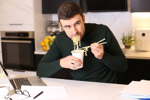 istock Man eating delicious instant noodles 1447703672