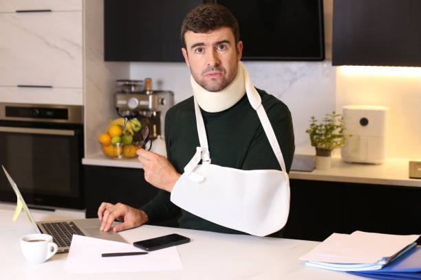 Worker doing home office after an accident stock photo