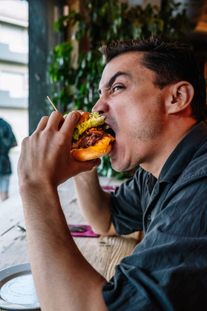 istock Hungry man eating tasty burger 1447704527