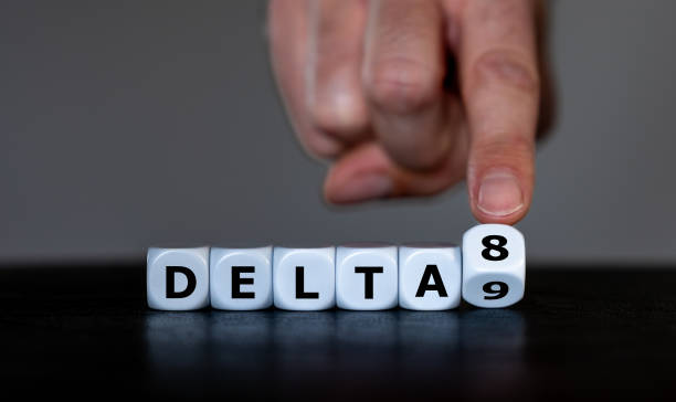 Hand turns dice and changes the expression 'delta 9' to 'delta 8'. Symbol for the Delta-8-tetrahydrocannabinol, a psychoactive cannabinoid found in the Cannabis plant. stock photo