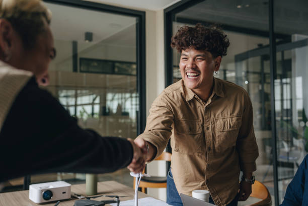 istock Smiling colleagues shaking hands in the office 1447712086