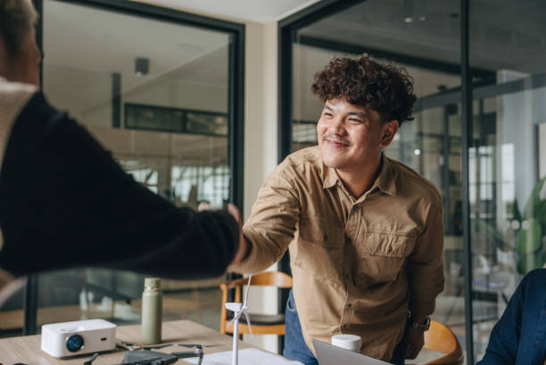 istock Smiling colleagues shaking hands in the office 1447712139