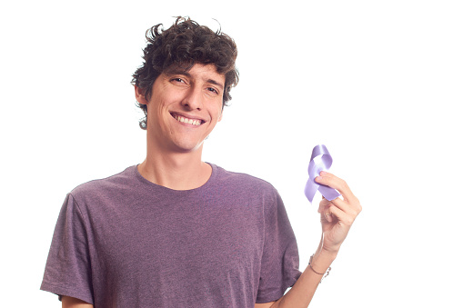 Young man holding purple ribbon, world cancer day february 4, on white background