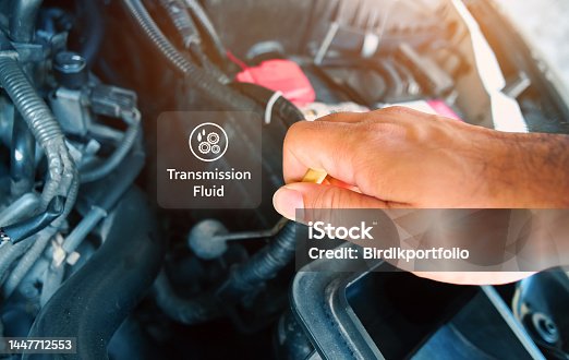 istock Check the transmission fluid level and gear oil deterioration by a mechanic with transparent gear oil warning symbols on center 1447712553