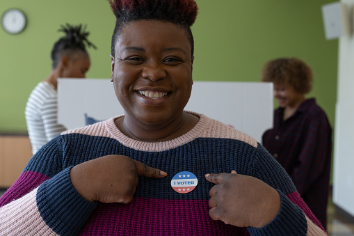 An African American woman voting at a local community center.