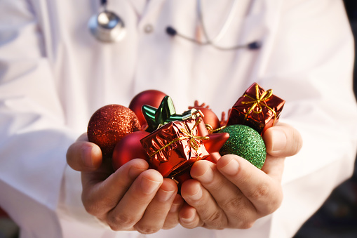 Doctor's hands holding Christmas ornaments. Happy and healthy new year concepts