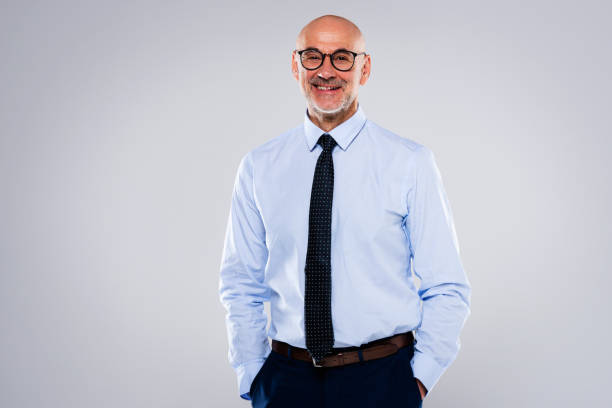 istock Smiling mature male CEO standing at isolated background 1447731567