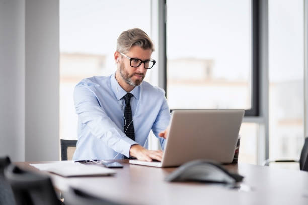 istock Executive businessman wearing shirt and tie while sitting at office desk and working 1447731641