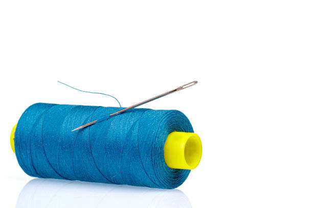 istock Macro skein of blue thread with a needle on a white background 1447733519