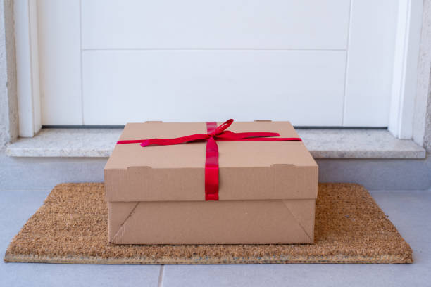 christmas gift box delivered to house front door - doormat door christmas holiday imagens e fotografias de stock