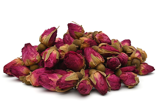 Dried rose buds tea on white background