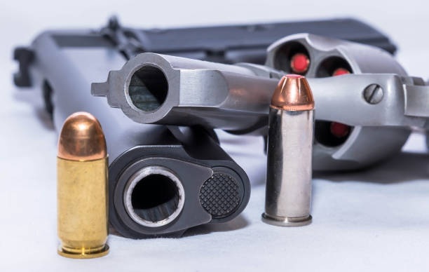 istock A revolver and a pistol with bullets next to them 1447740236