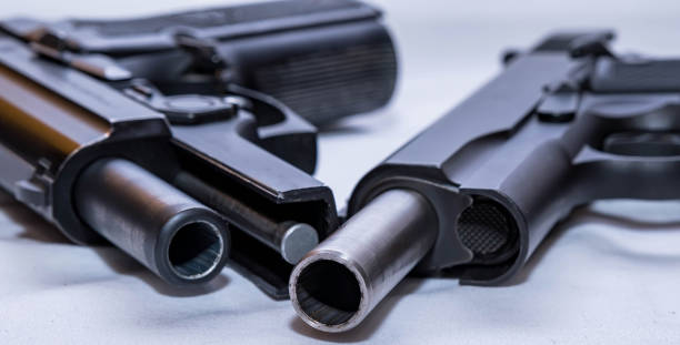istock The slides racked open on two different pistols 1447740258