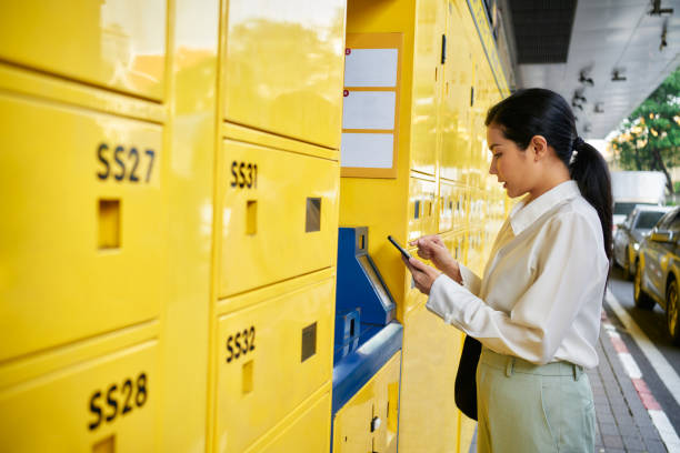 Digital nomad woman using phone making Contactless payments renting locker box at public transportation service.