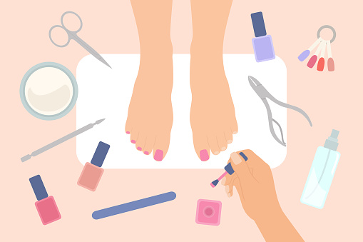 Top View Of Female Feet In Nail Salon. Female Hands Applying Nail Polish On Toenails. Nail Care Concept