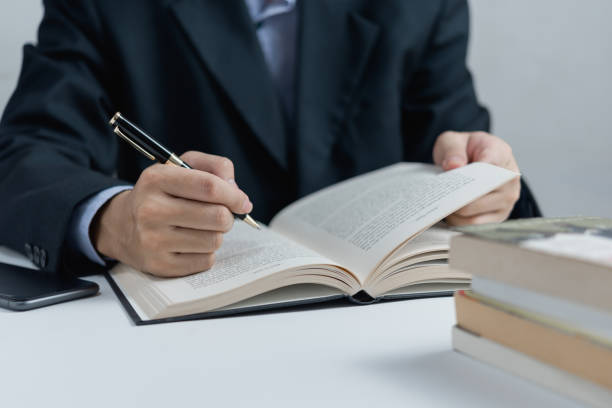 istock Businessperson reading and writing on book.education studying knowledge development and cognition learning concept. 1447749413