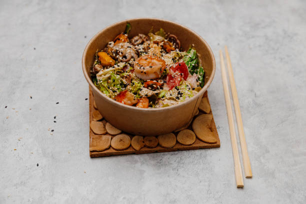 istock Seafood salad in a craft plate on a gray background. Side view. 1447751510