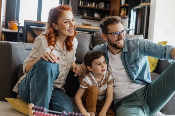 Lovely family watching TV at home stock photo