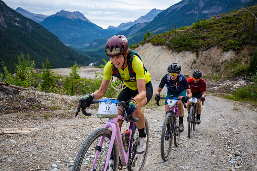 Two women and a man compete together in the 2022 TransRockies Gravel Royale race in British Columbia, Canada. The TransRockies Gravel Royale is a four-day gravel bicycle stage race that takes the participants on a selection of gravel roads, forestry and mining roads along with some sections of singletrack trail.  Men, women and all age categories compete on the same course and take part in the mass start at the same time every day.  Gravel bicycles are similar to road bicycles but have sturdy wheels and oversized tires for riding on rough terrain. (John Gibson Photo/Gibson Pictures)