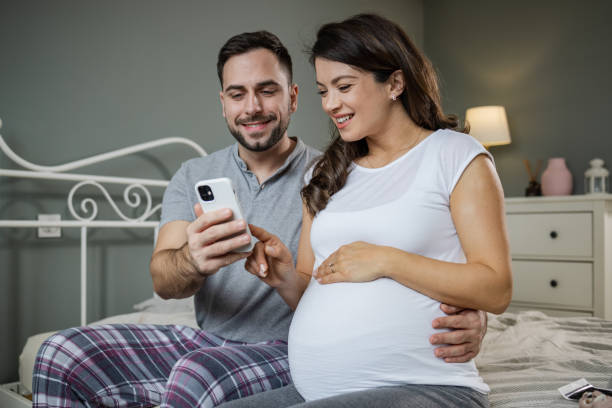 istock Mid-adult expectant using smartphone 1447756378