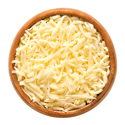 Shredded mozzarella cheese, in a wooden bowl. Grated low-moisture part-skim mozzarella, an Italian cheese, made of pasteurized cow milk, rolled in starch to avoid sticking. Used for pizza and pasta.