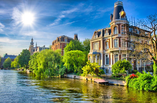 fiume amstel, con splendide case in amsterdam, olanda, nether - amstel river foto e immagini stock