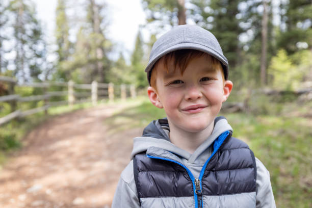 istock Young 6 years old redhead boy smiling and looking at the camera while hiking 1447764899