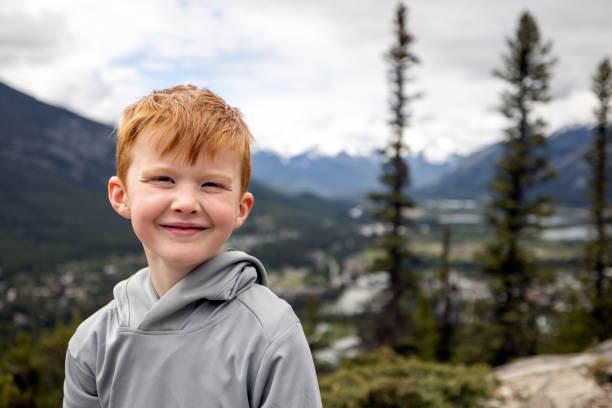 Young 6 years old redhead boy smiling and looking at the camera while hiking