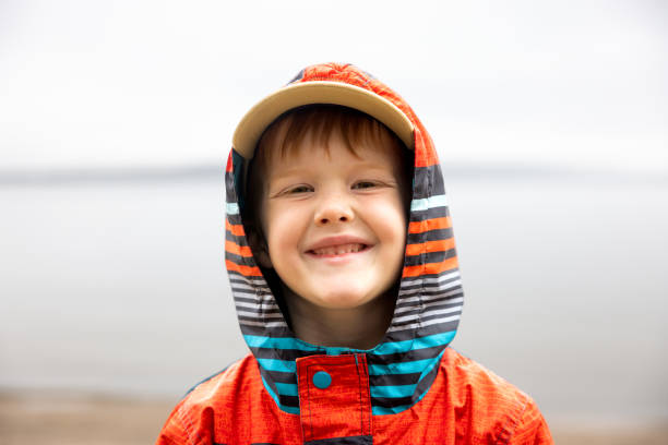 Young 6 years old redhead boy smiling and looking at the camera while hiking in Pancake Bay, Ontario, Canada