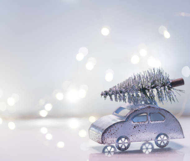 istock Little silver car with Christmas tree on top against white background 1447765296