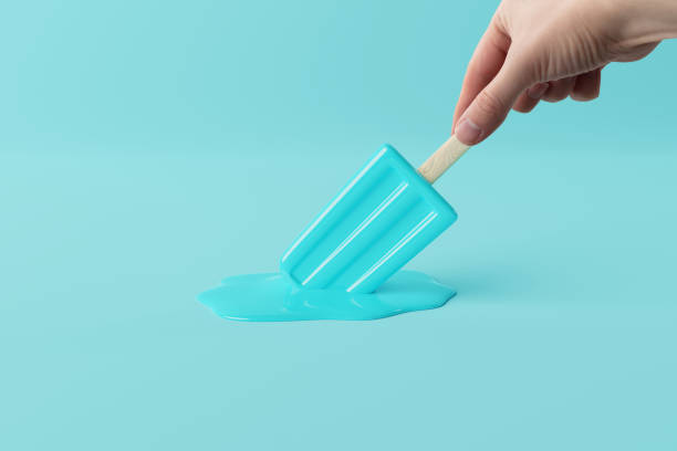 istock Hand holds melted blue ice lolly on a pastel background. 1447765574