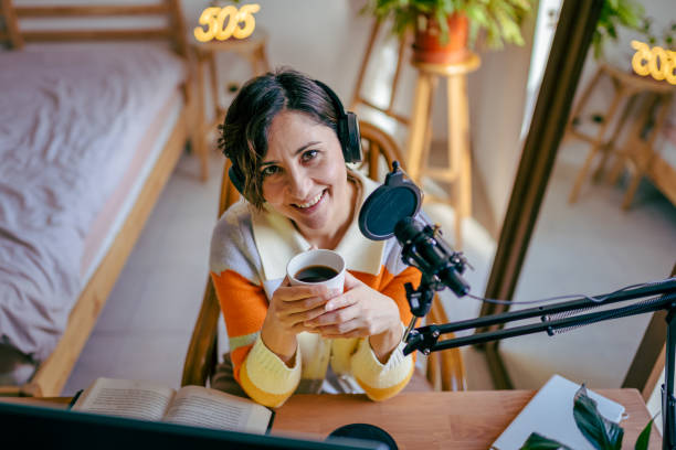 istock Beautiful young woman recording podcast 1447768992