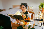 Beautiful young woman recording podcast