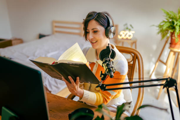 Beautiful young woman recording podcast Beautiful young woman recording podcast audio book stock pictures, royalty-free photos & images