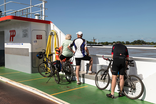 Rijswijk, Netherlands, July 17, 2021; Cyclists on the ferry across the river Nederrijn between Rijswijk and Wijk bij Duurstede.