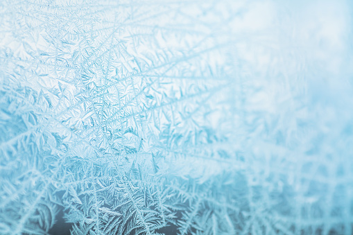 Frosty patterns on the edge of a frozen window.