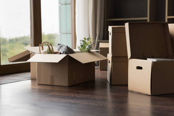 Big cardboard boxes with packed personal stuff stacked on floor
