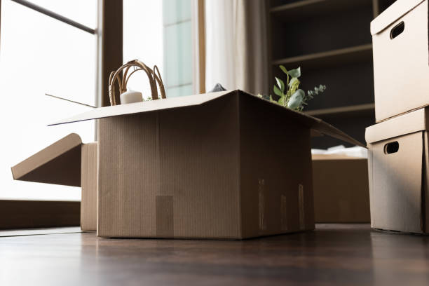 istock Stuffed cardboard boxes with packed personal belongings stacked on floor 1447771782