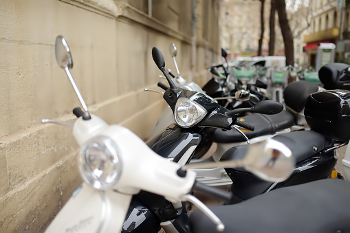 Motorcycle, scooters are parked on the city road. In old European cities there is a problem of parking vehicles. Compact transport is a choice in old towns with narrow streets.