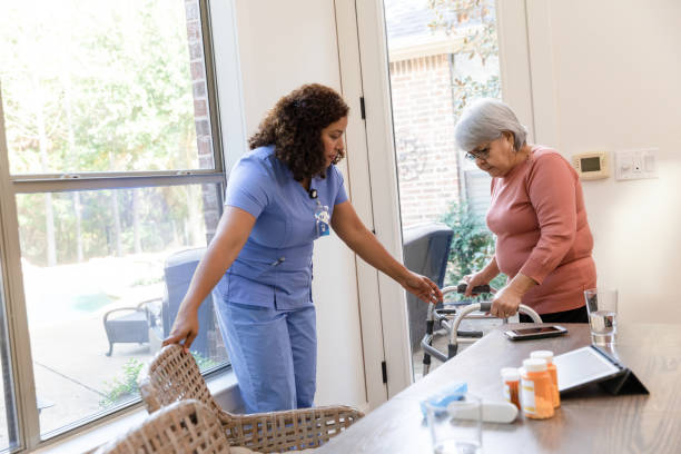 istock Female nurse helps patient sit at the table 1447776702