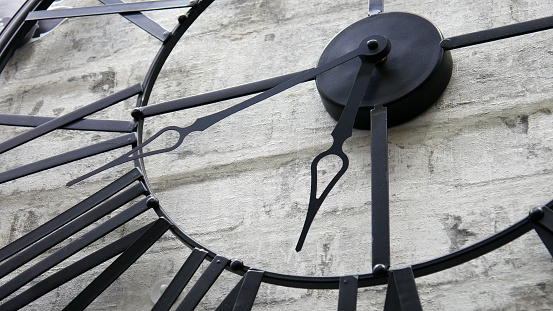 A big iron decorative clock hanging on the wall close-up