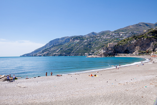Maiori, Salerno - April 28, 2022: Beach of Maiori town at noon on Amalfi coast in Italy, some people are on the beach.