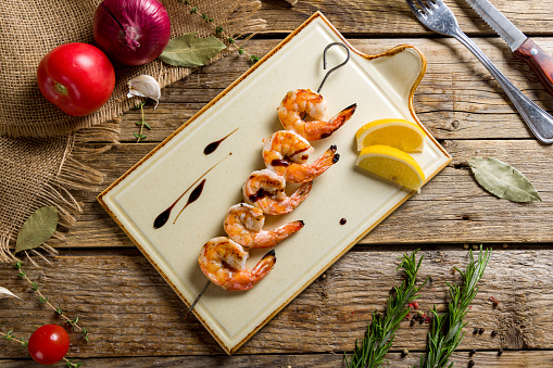 tiger shrimp kebab on plate top view on wooden table