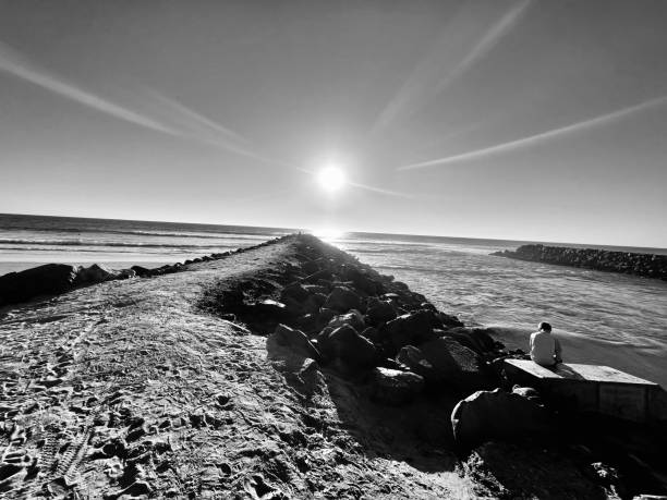 istock Sunset over ocean jetty with boy 1447780988