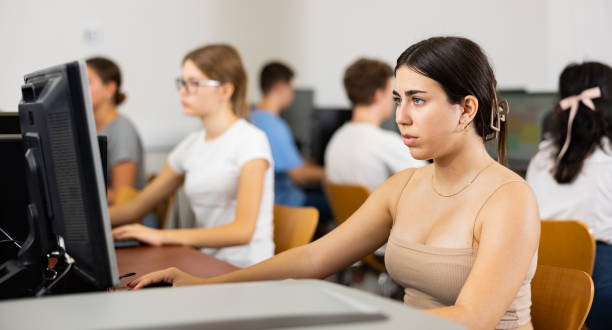 istock Concentrated Latin female student using PC and studying computer science in the classroom 1447781616