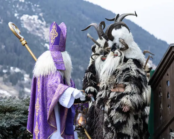 St. Nicholas and a pair of Krampus prepare for the traditional Christmas procession, Austria, Salzburg. High quality photo